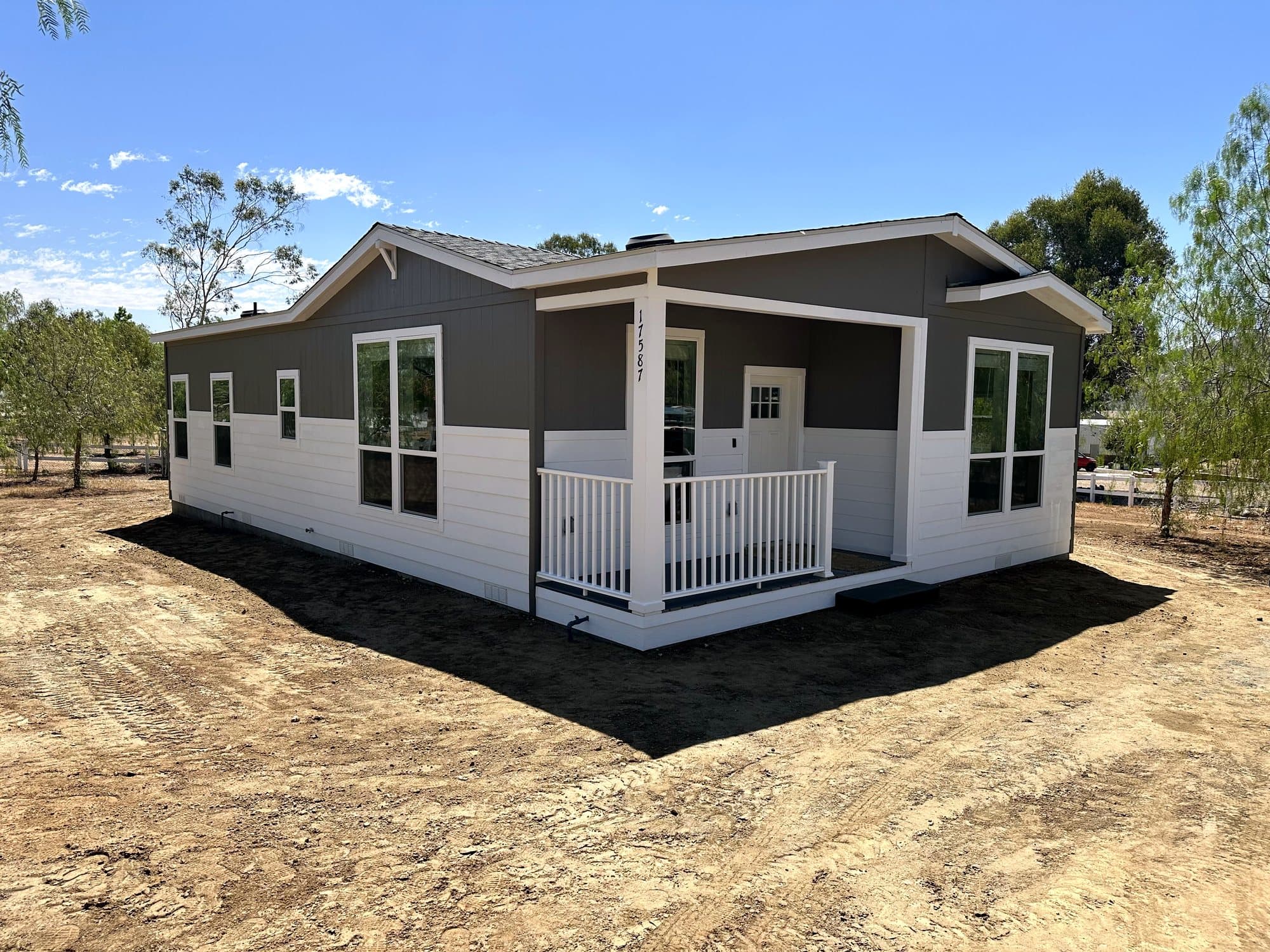 Gray and white manufactured home with a covered front porch